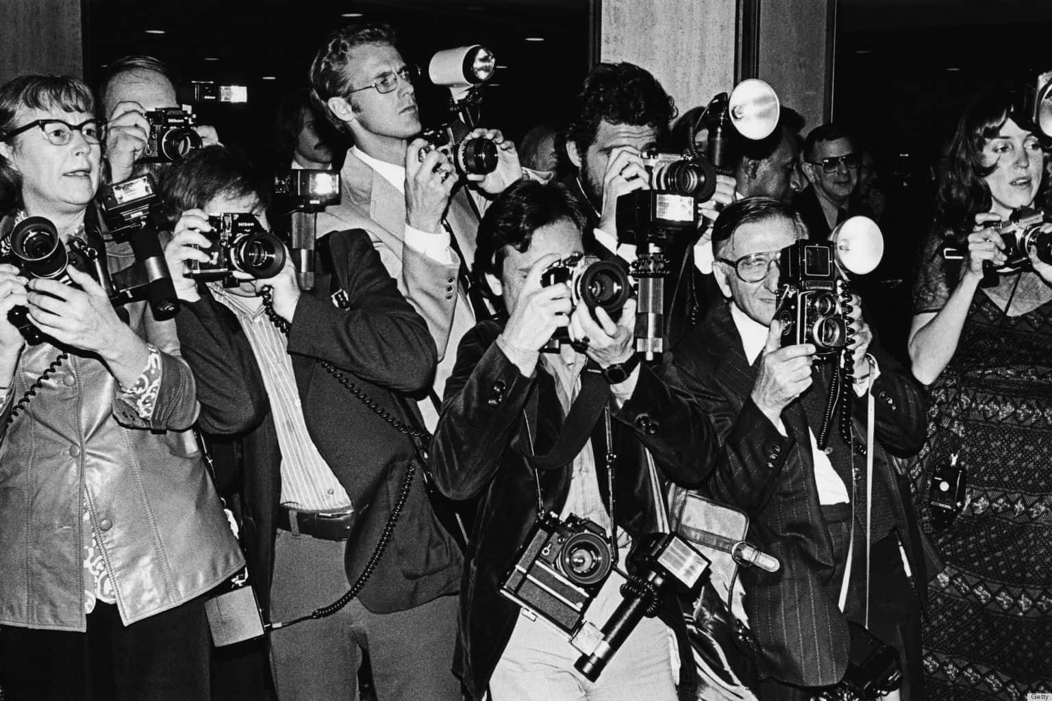 Paparazzi in action with cameras and flashlights at an event