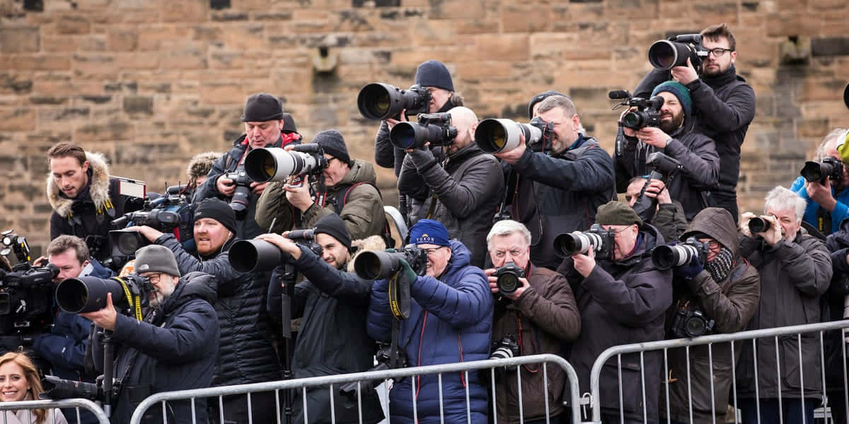 A swarm of paparazzi trying to get photos of a celebrity. Wallpaper