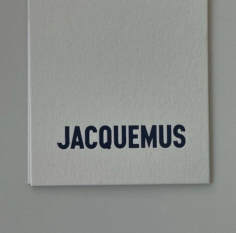 The Iconic Jacquemus Logo on White Paper Wallpaper