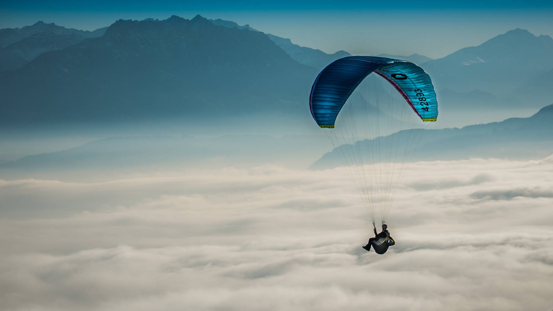 Paraglidingüber Dicken Wolken Wallpaper