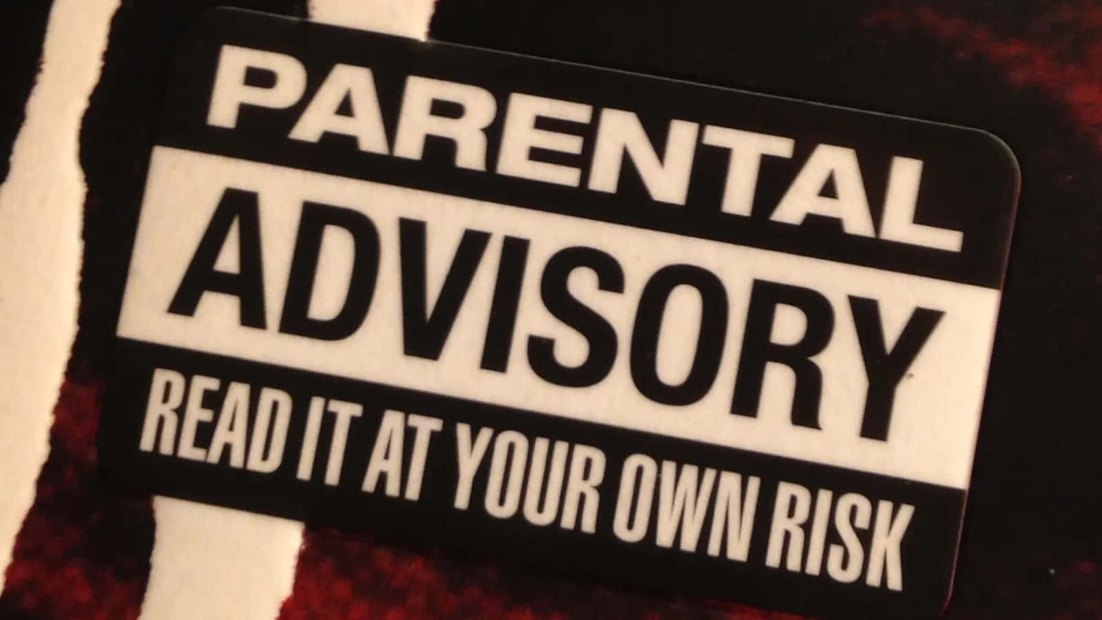 A Sticker That Says Parental Advisory Read At Your Own Risk Wallpaper