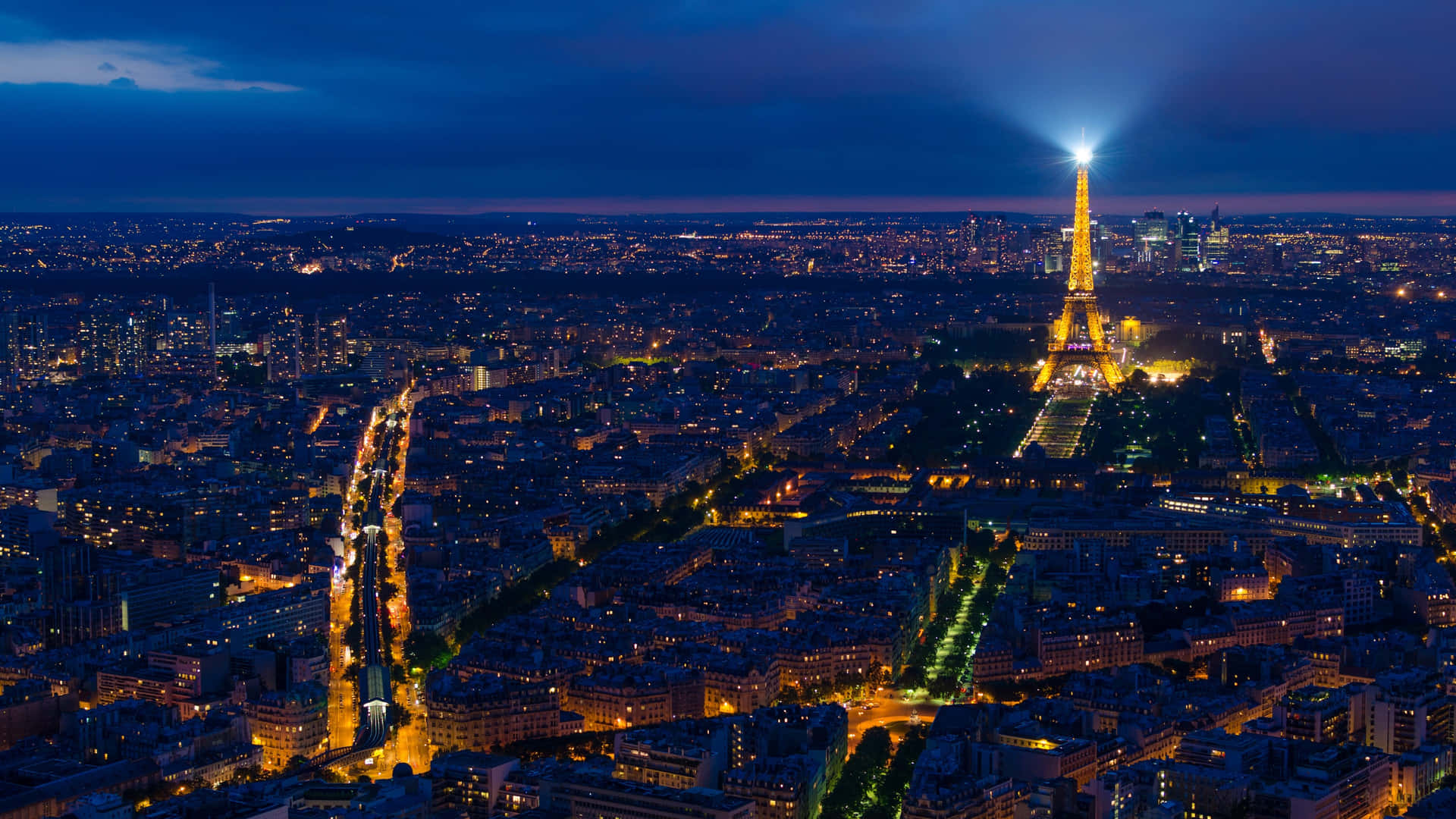 Et romantisk udsyn af Paris om natten Wallpaper