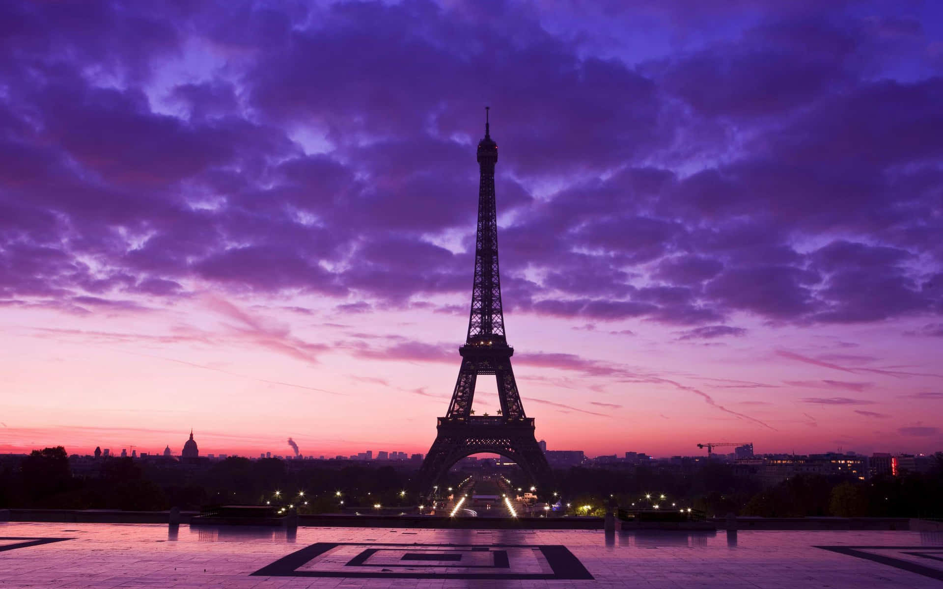 Magníficatorre Eiffel Iluminando A Cidade Do Amor Durante A Noite. Papel de Parede