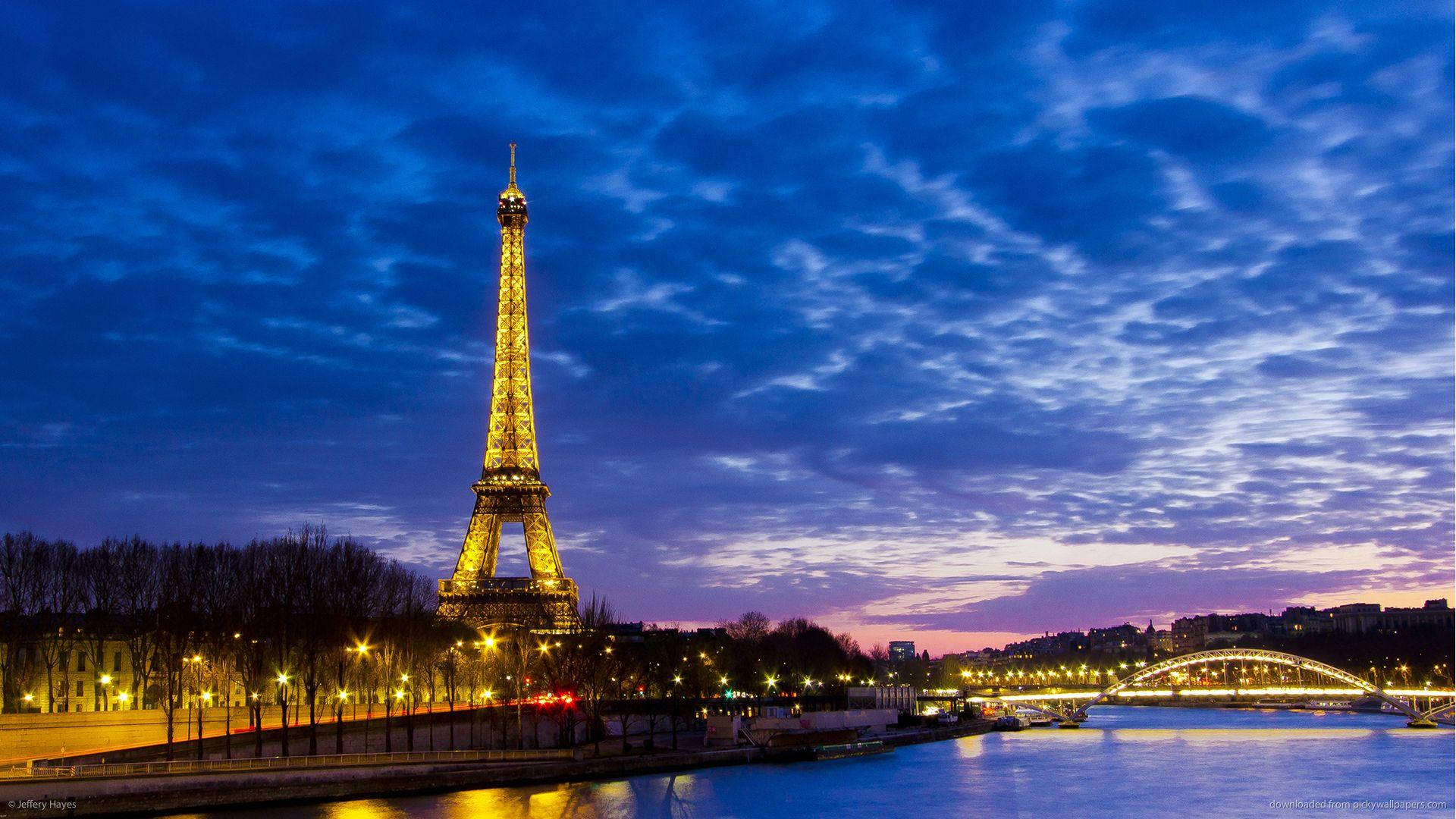 The iconic Paris Eiffel Tower overlooking the Seine River Wallpaper