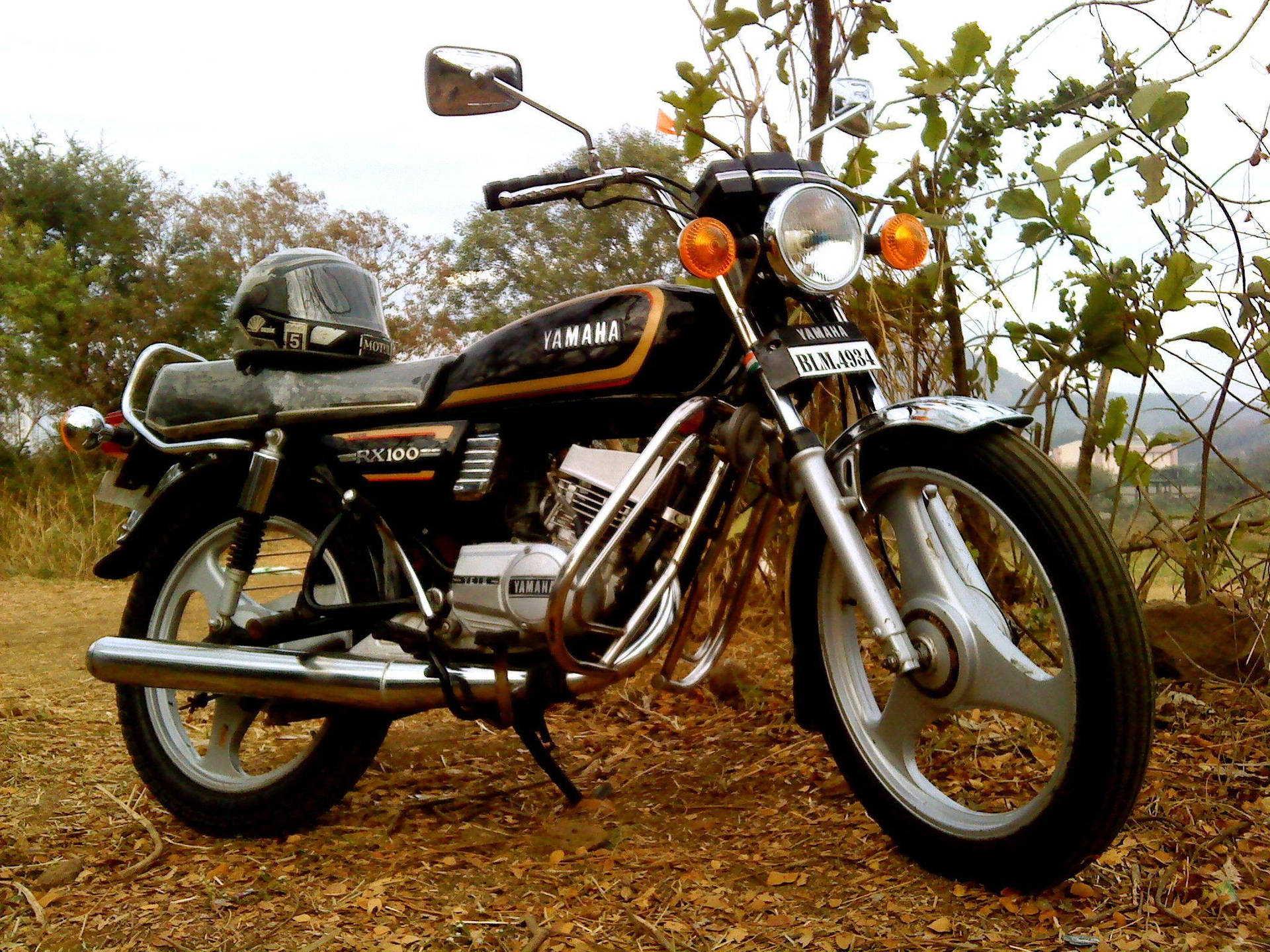 Motocicletayamaha Rx100 Negra Estacionada Fondo de pantalla