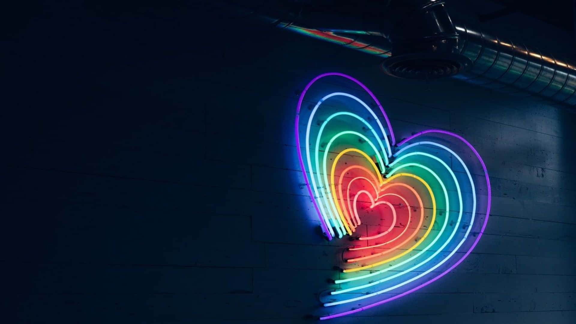 Unsegno Al Neon A Forma Di Cuore Arcobaleno In Una Stanza Buia