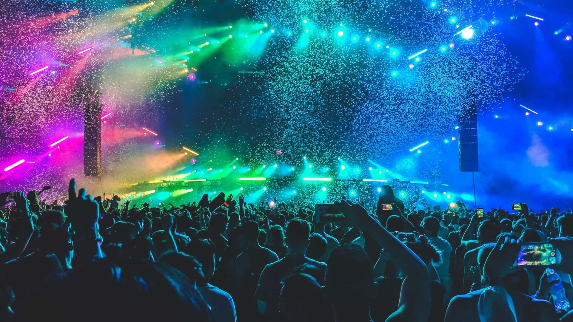 A Crowd At A Concert With Colorful Lights
