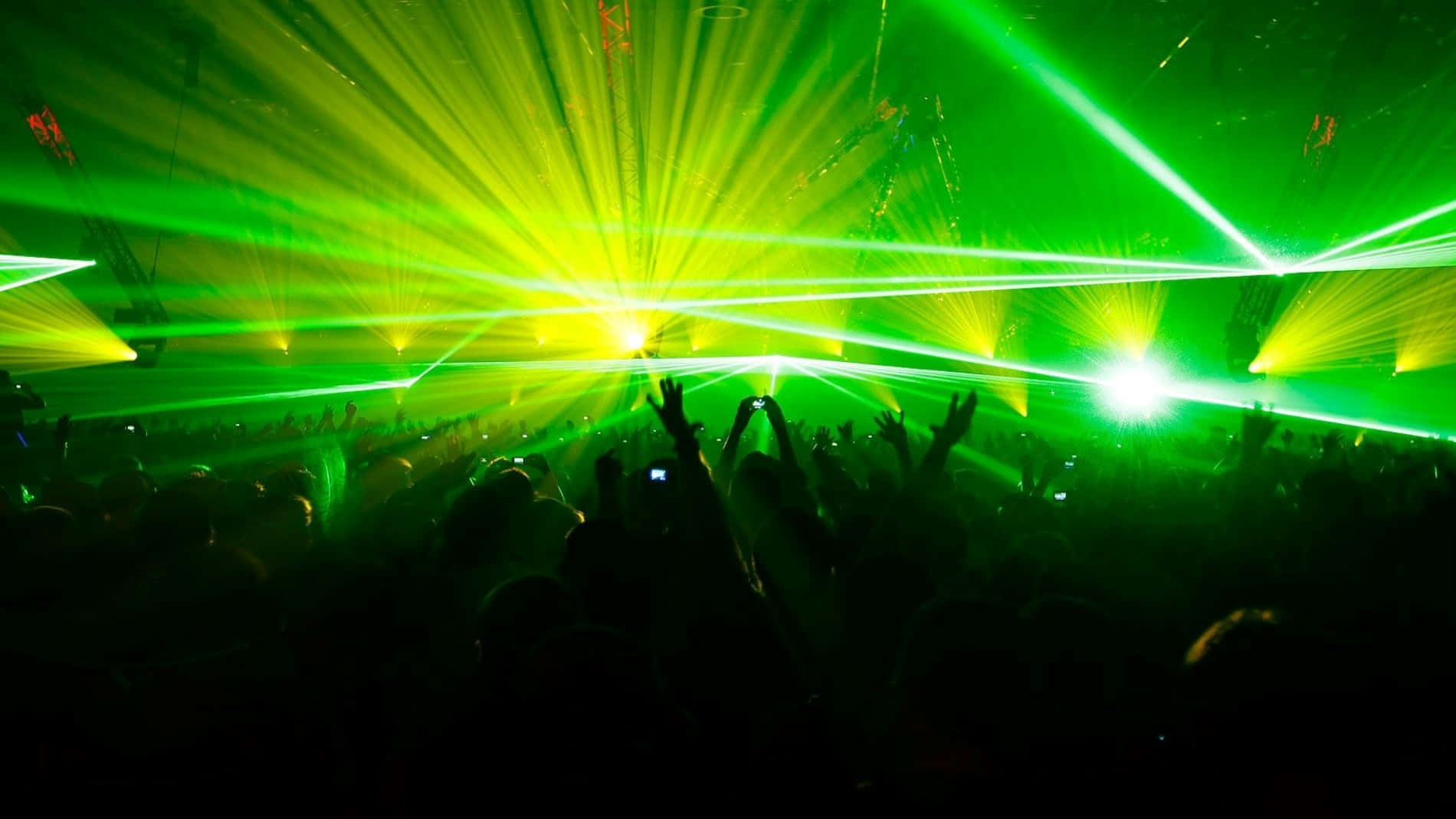 A Crowd Of People At A Concert With Green Lasers