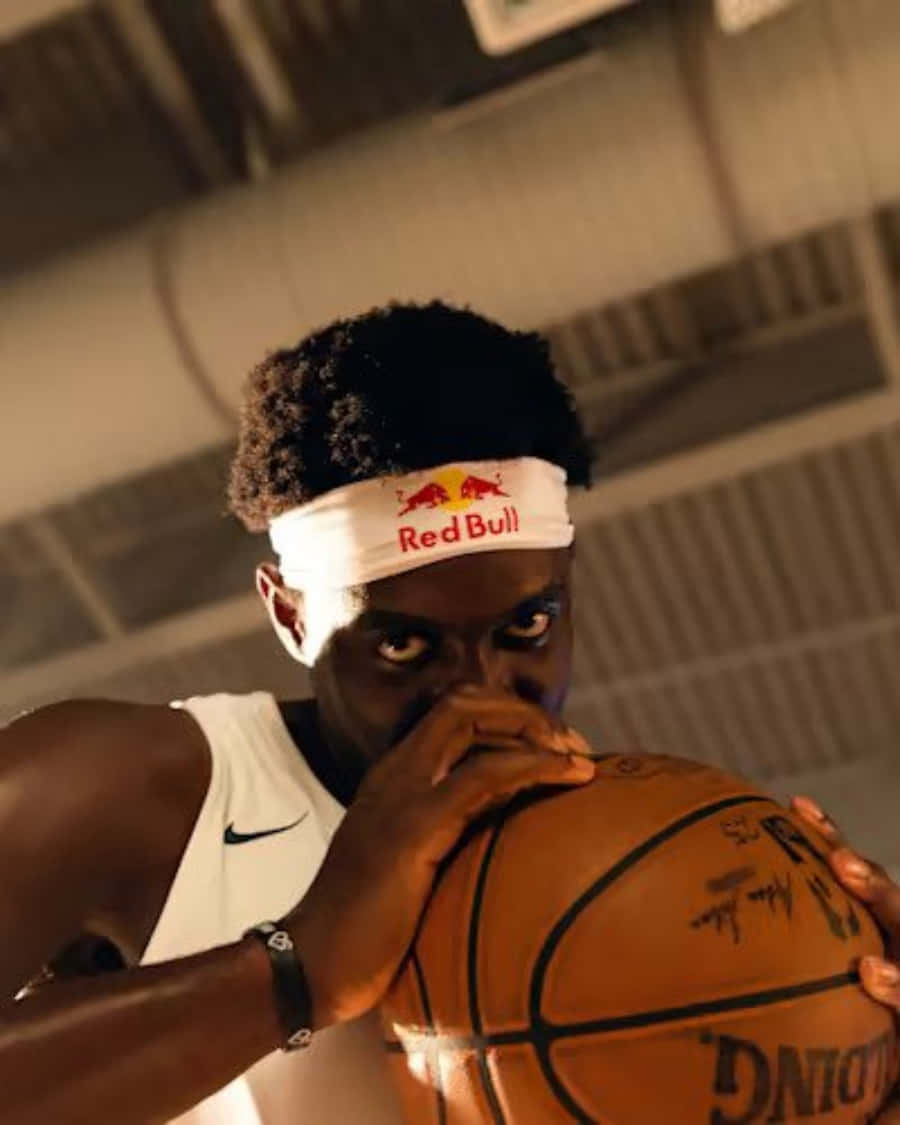 A Basketball Player Is Holding A Basketball In His Mouth