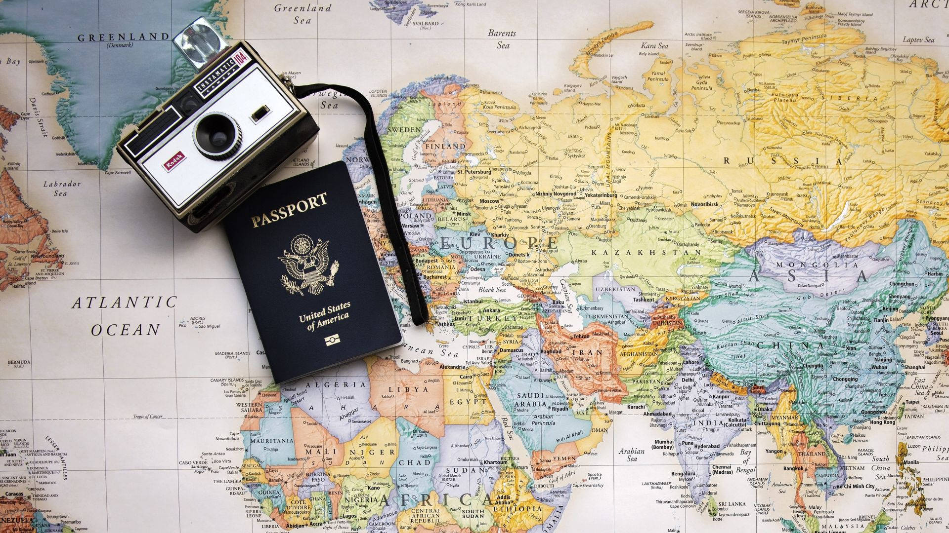 Passport And Camera On World Map Wallpaper
