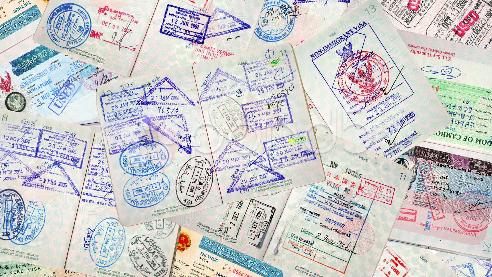 Many Different Passports And Visas Are Arranged In A Pile