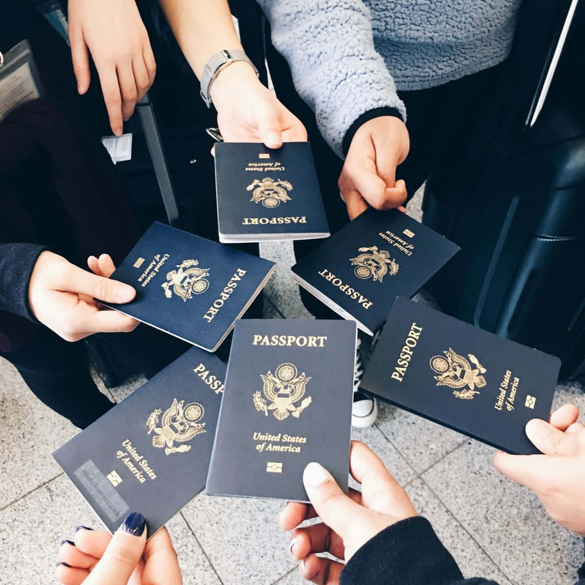 A Group Of People Holding Passports Together