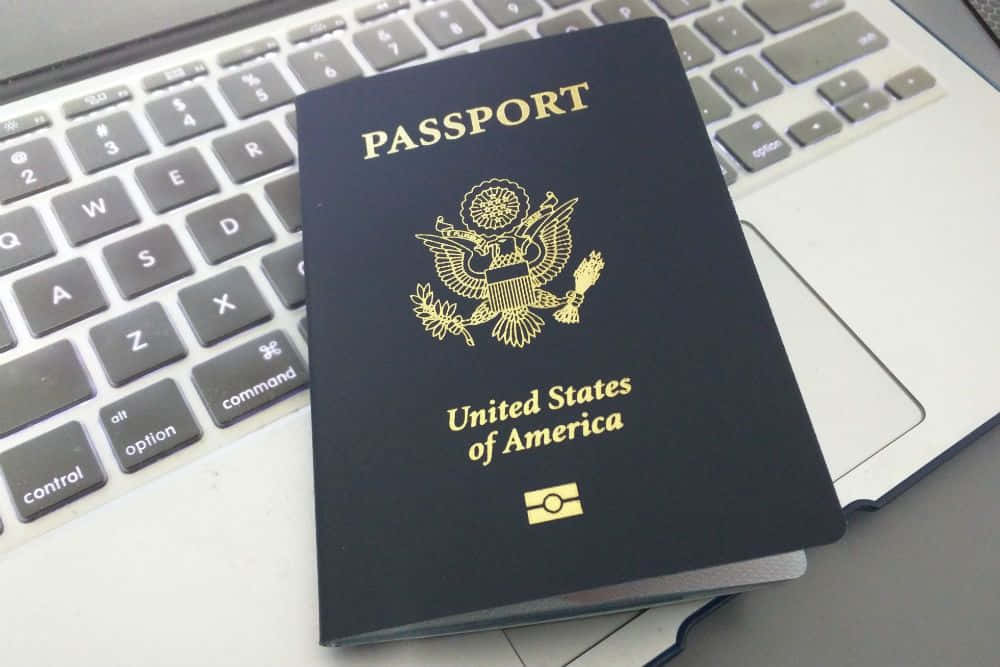 A Passport Sitting On Top Of A Laptop