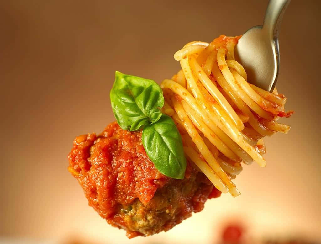 A Spoon With Spaghetti And Meatballs On It