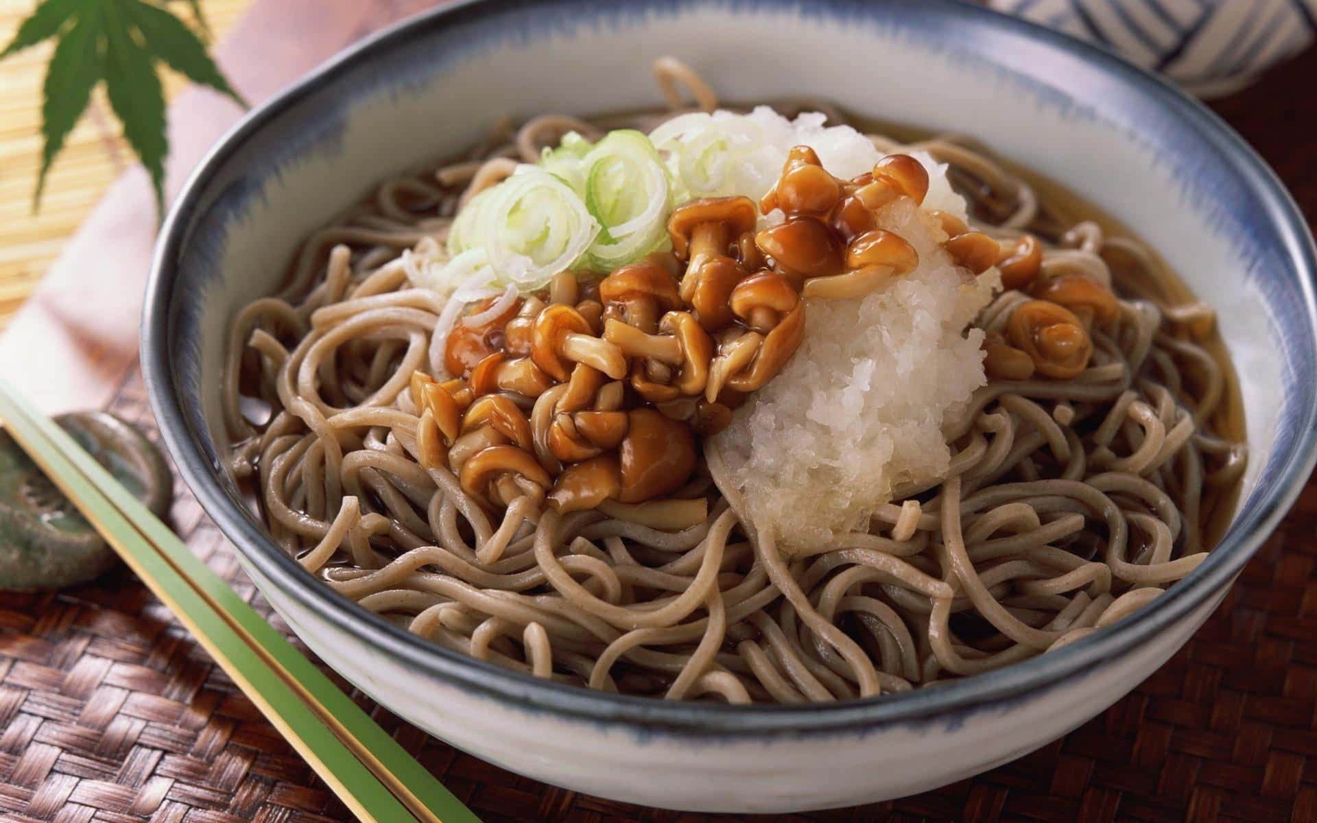 A Bowl Of Noodles With Peanuts And A Leaf