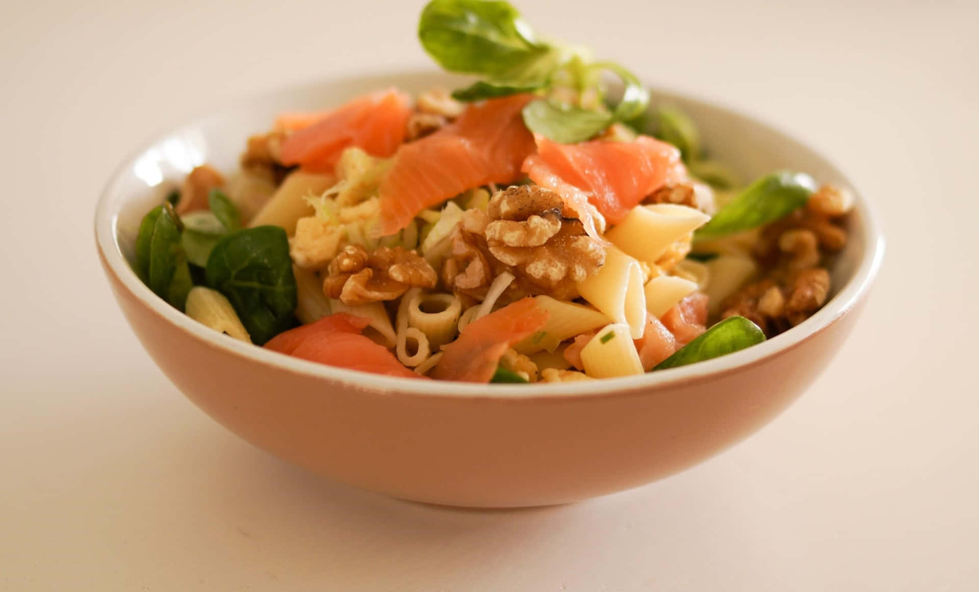 A Bowl Of Pasta With Walnuts And Salmon