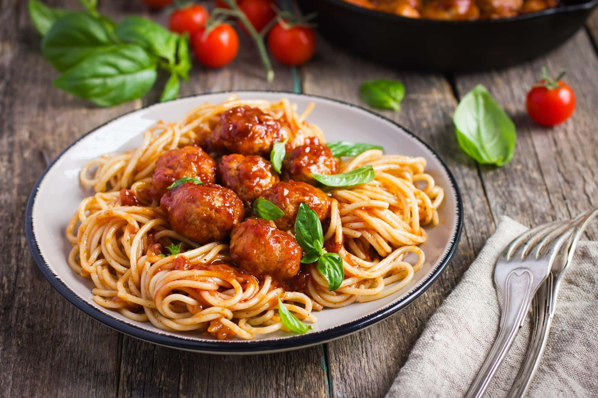 Spaghetti With Meatballs And Tomatoes On A Wooden Table