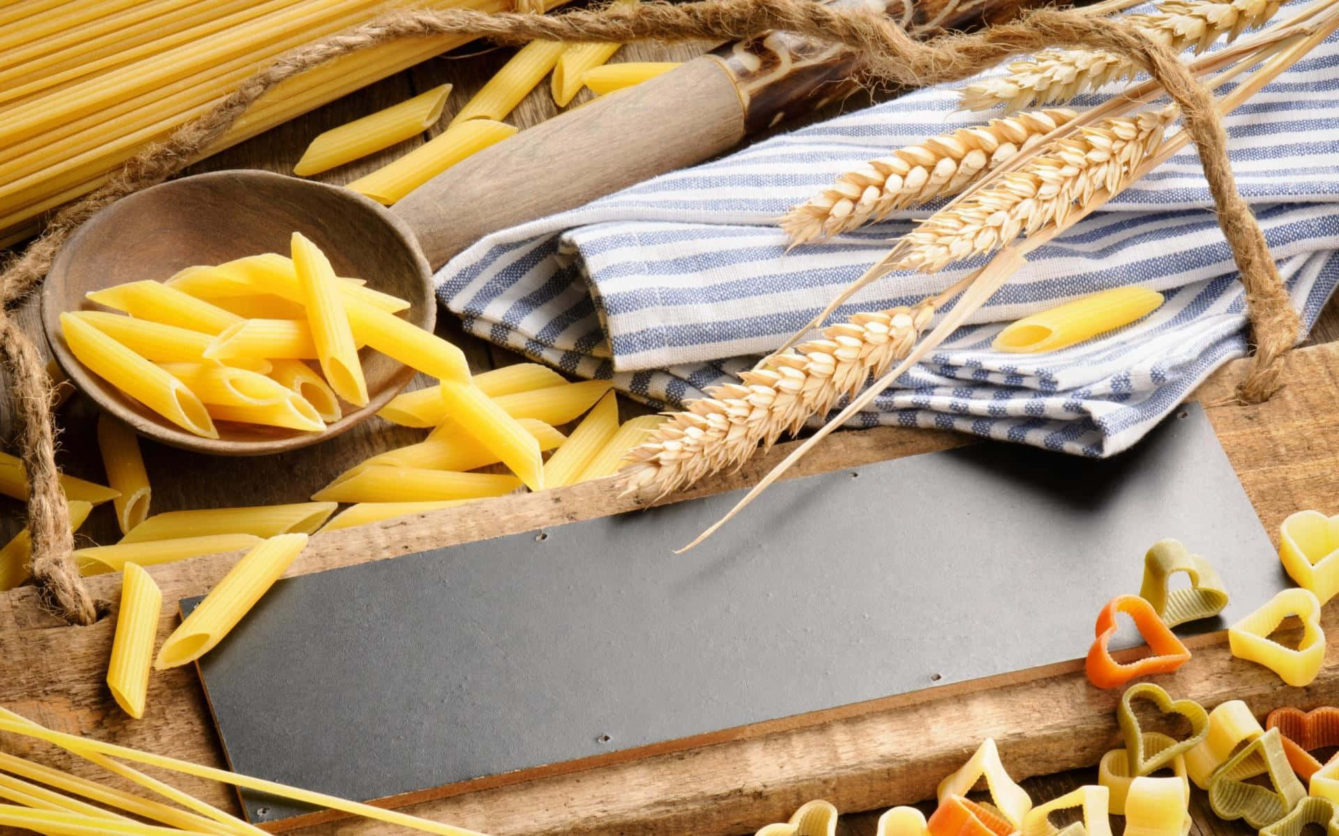 A Wooden Board With Pasta, Wheat And Other Items