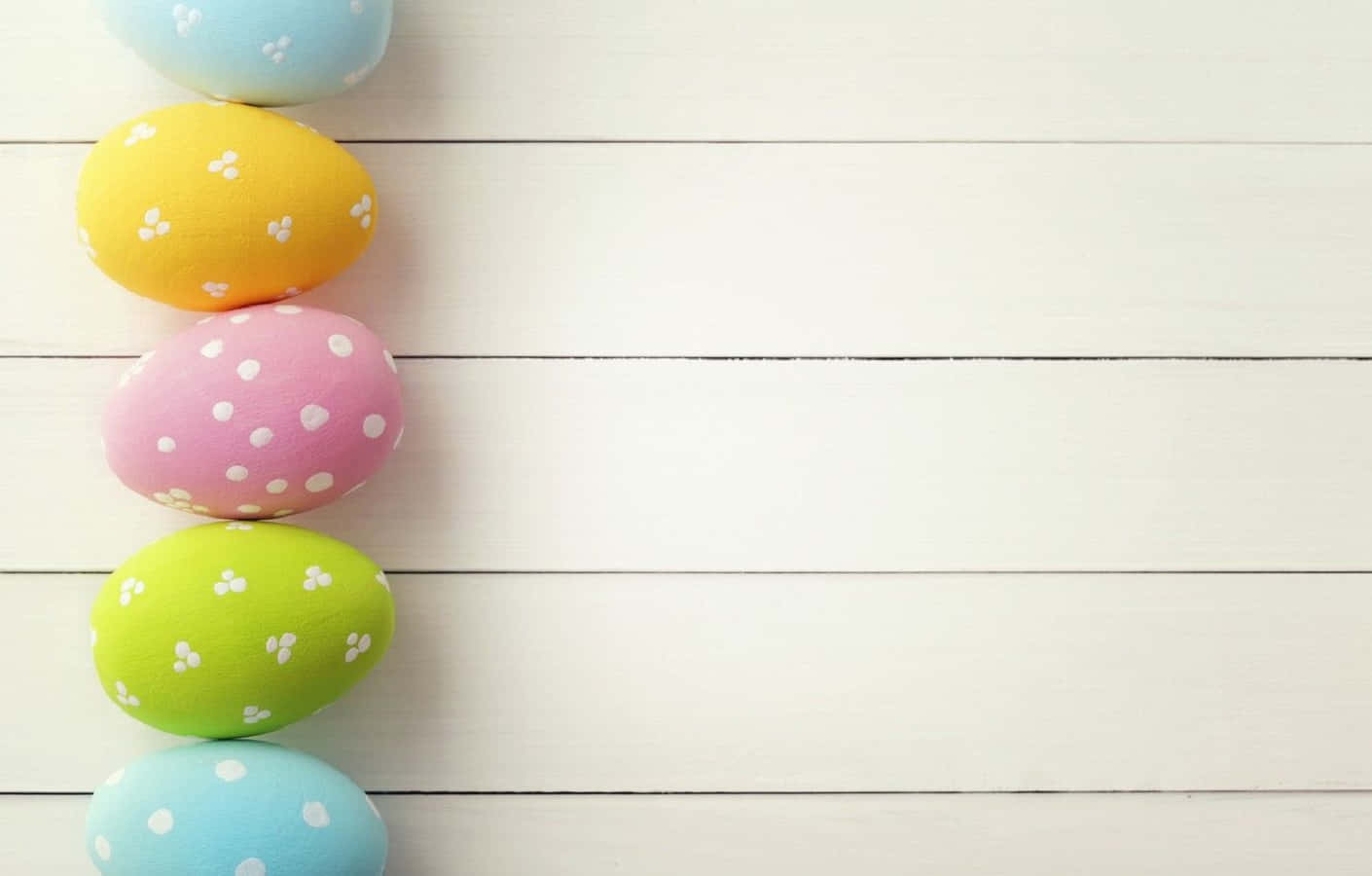 Colorful Easter Eggs On A White Wooden Background
