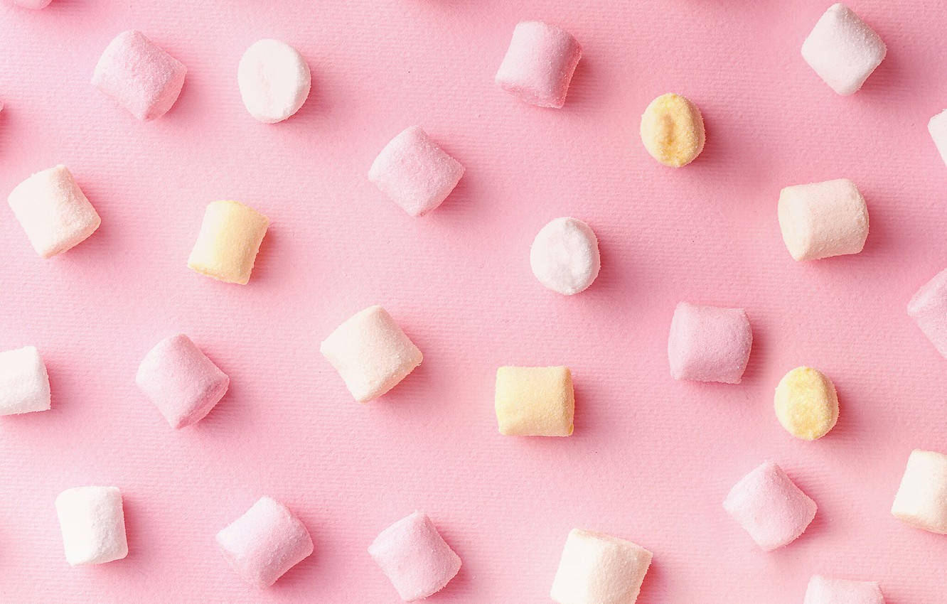 Pastelfarvet Pink Mini Marshmallows spredt over et glød af Blush Guld Wallpaper