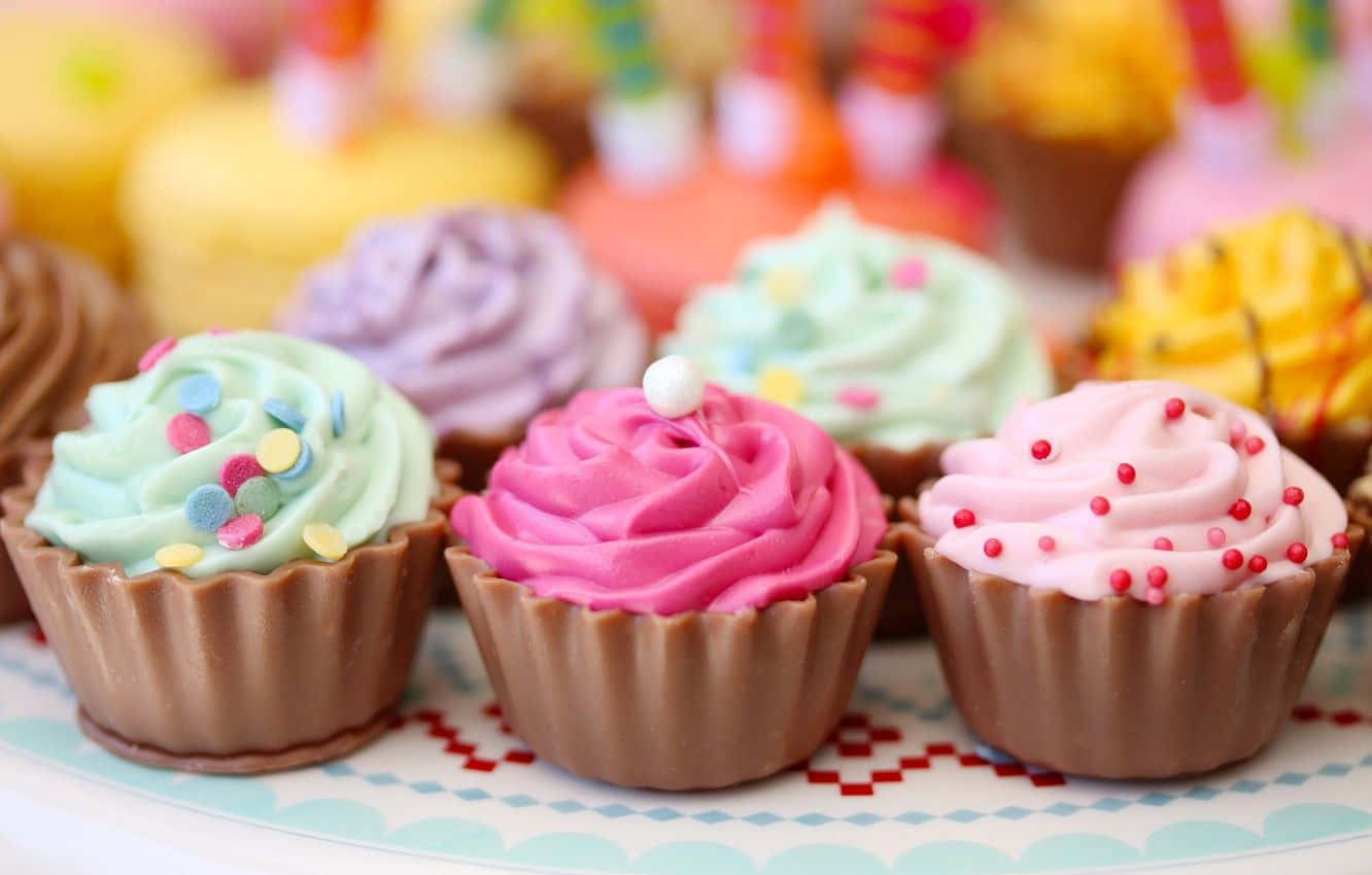 A Plate Of Cupcakes With Different Colors Of Frosting