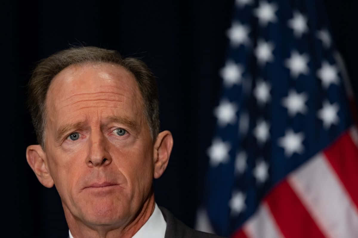 Pat Toomey Intently Listens to a Question During a Conference Wallpaper
