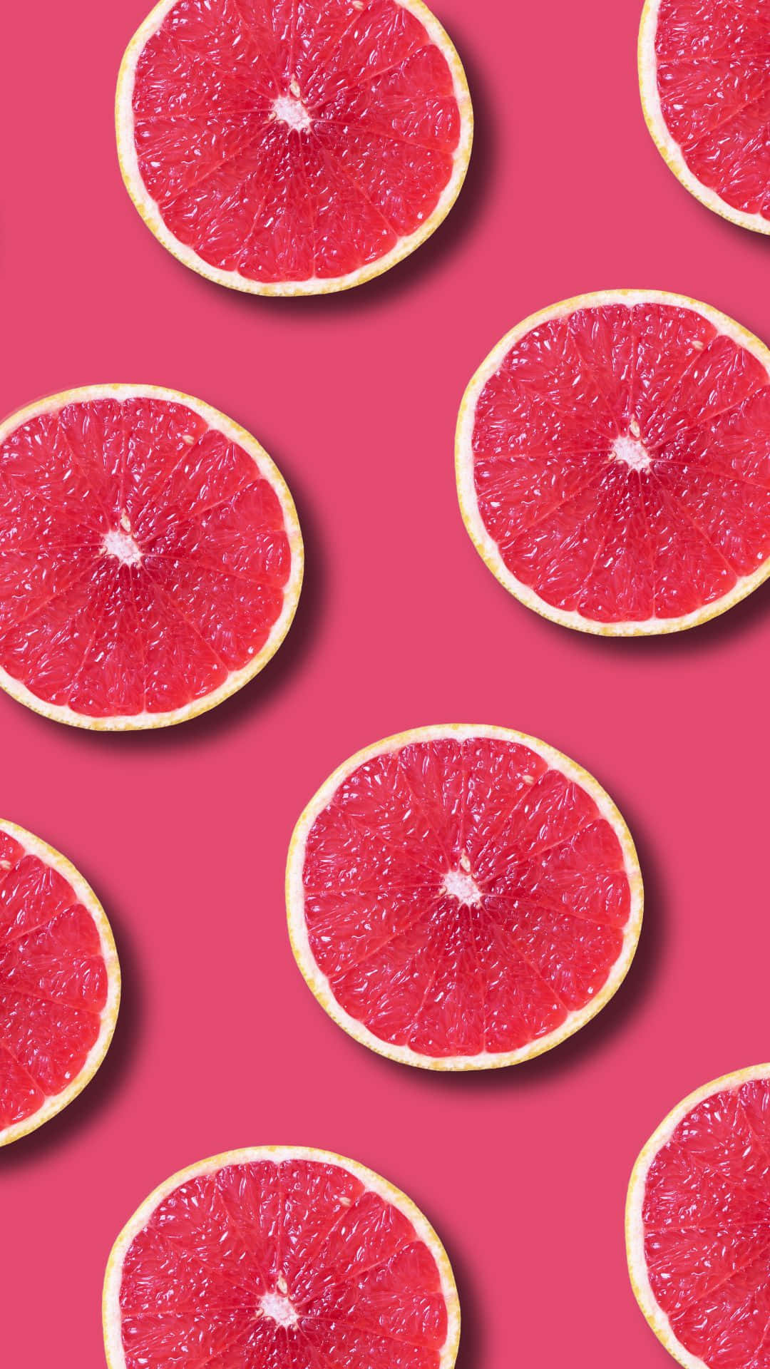 a pattern of grapefruit slices on a pink background