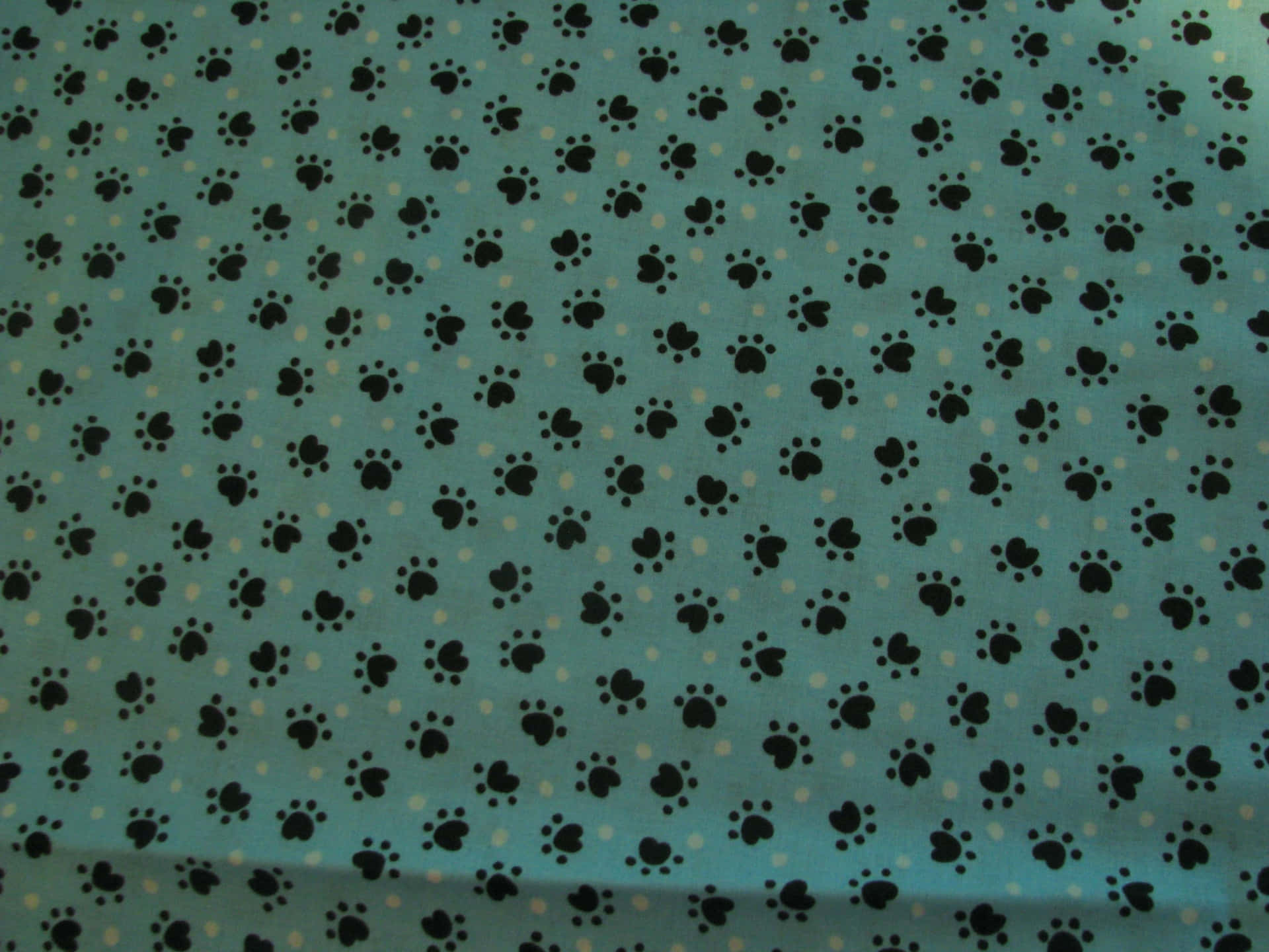 A Blue Fabric With Black Paw Prints On It