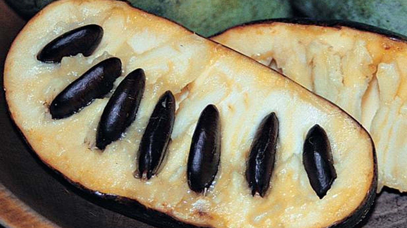Caption: Vibrant Pawpaw Fruit with Black Seeds Wallpaper
