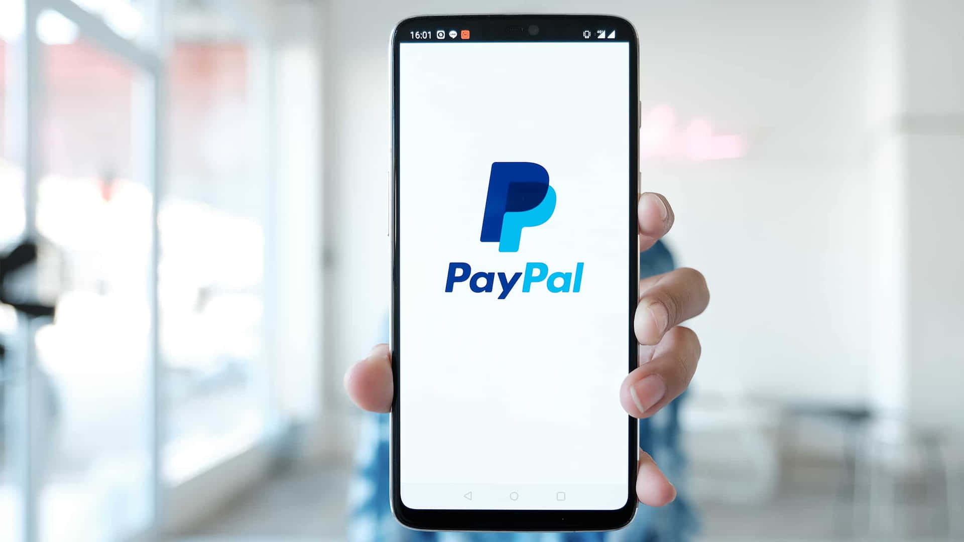 A Person Holding Up A Paypal Phone With The Logo On It