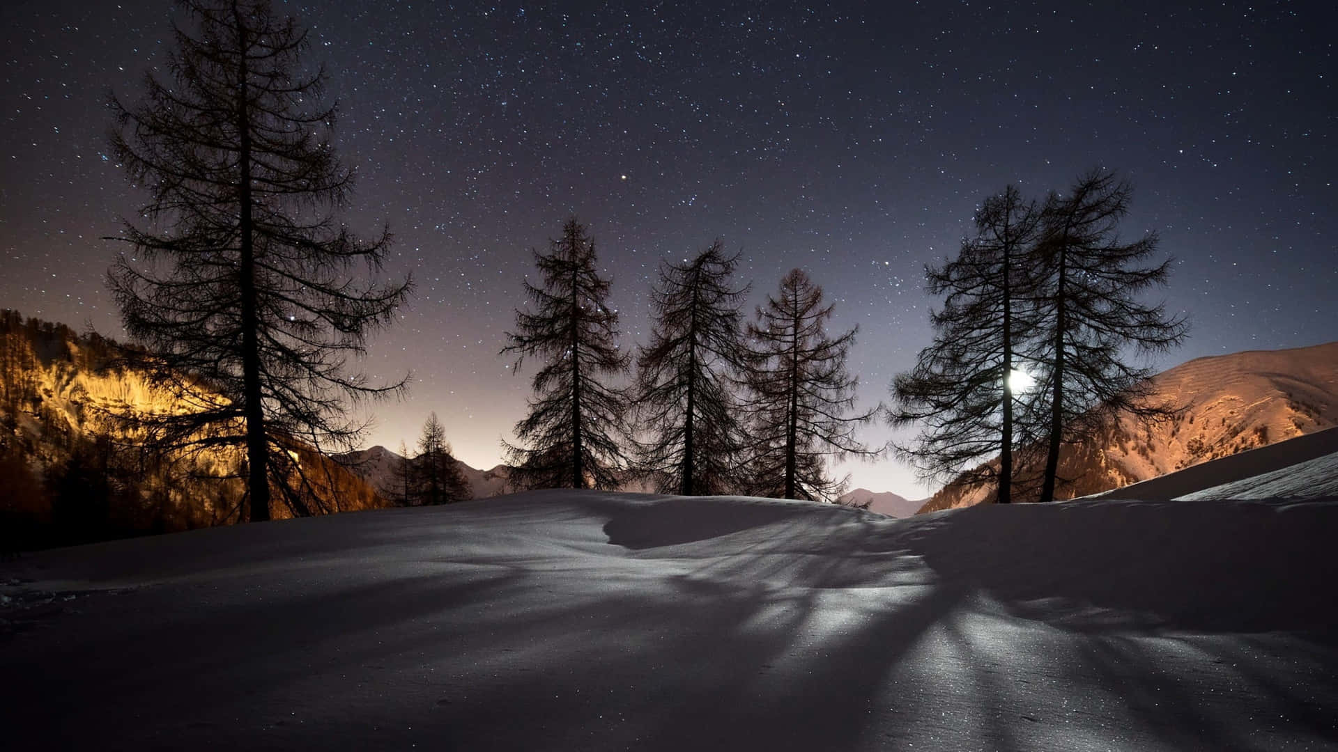 A Snow Covered Mountain With Trees And A Moon