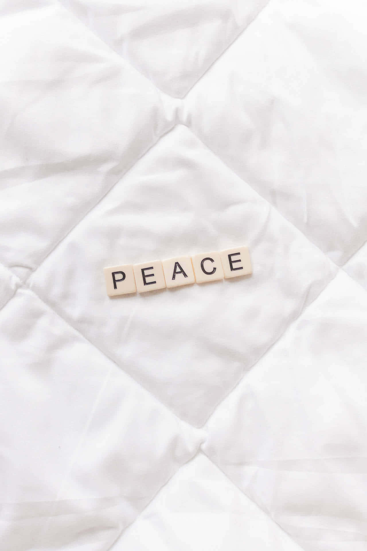 A White Quilt With The Word Peace On It