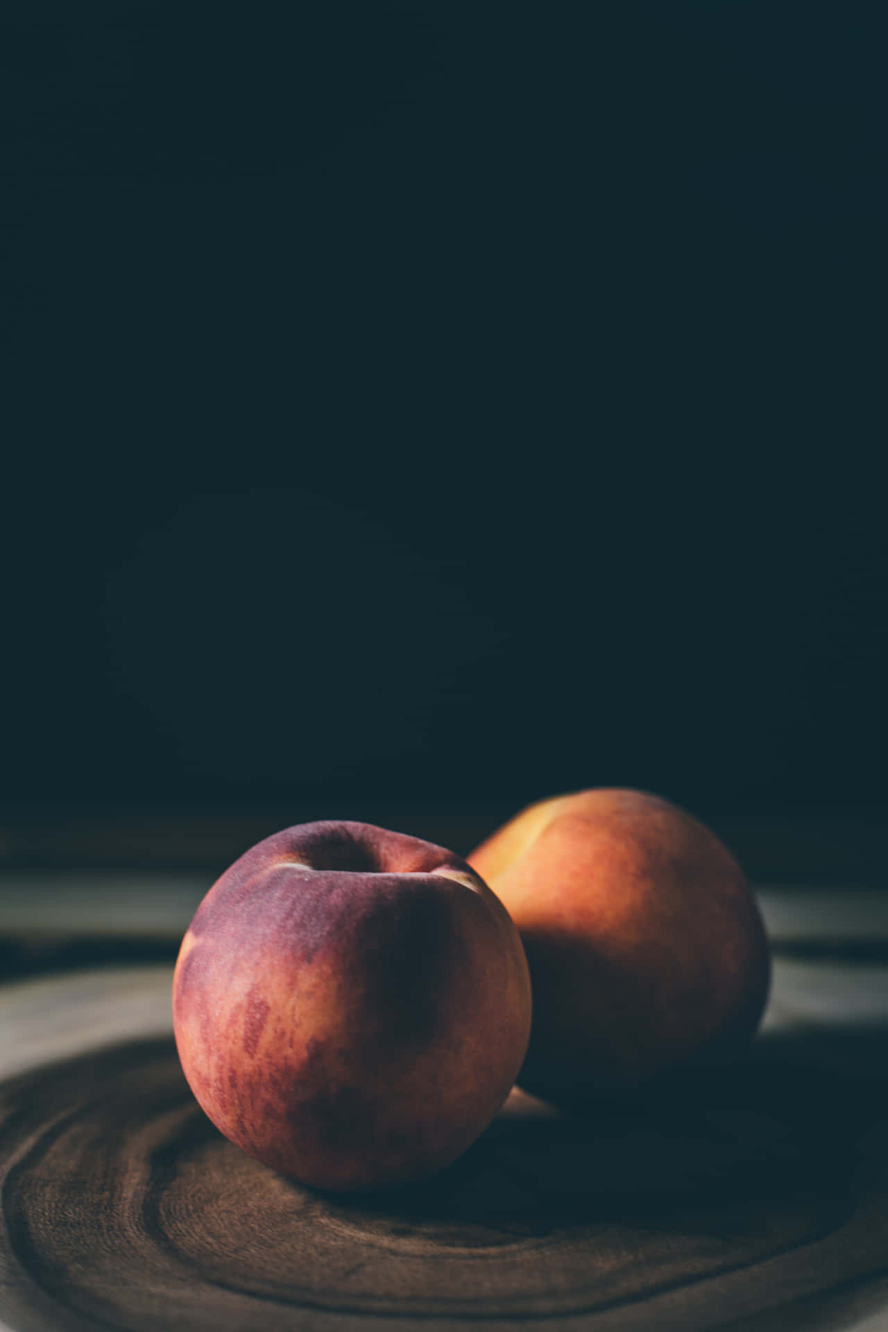 Two Peaches On A Wooden Board