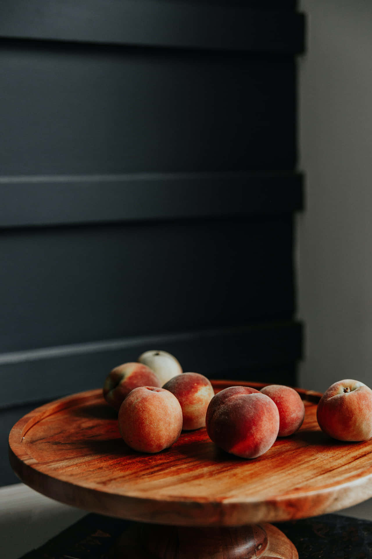 A Wooden Plate With Peaches On It