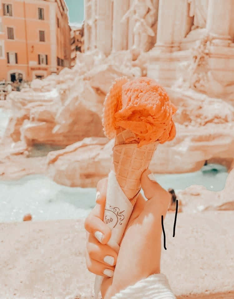 A Person Holding An Ice Cream Cone In Front Of The Trevi Fountain