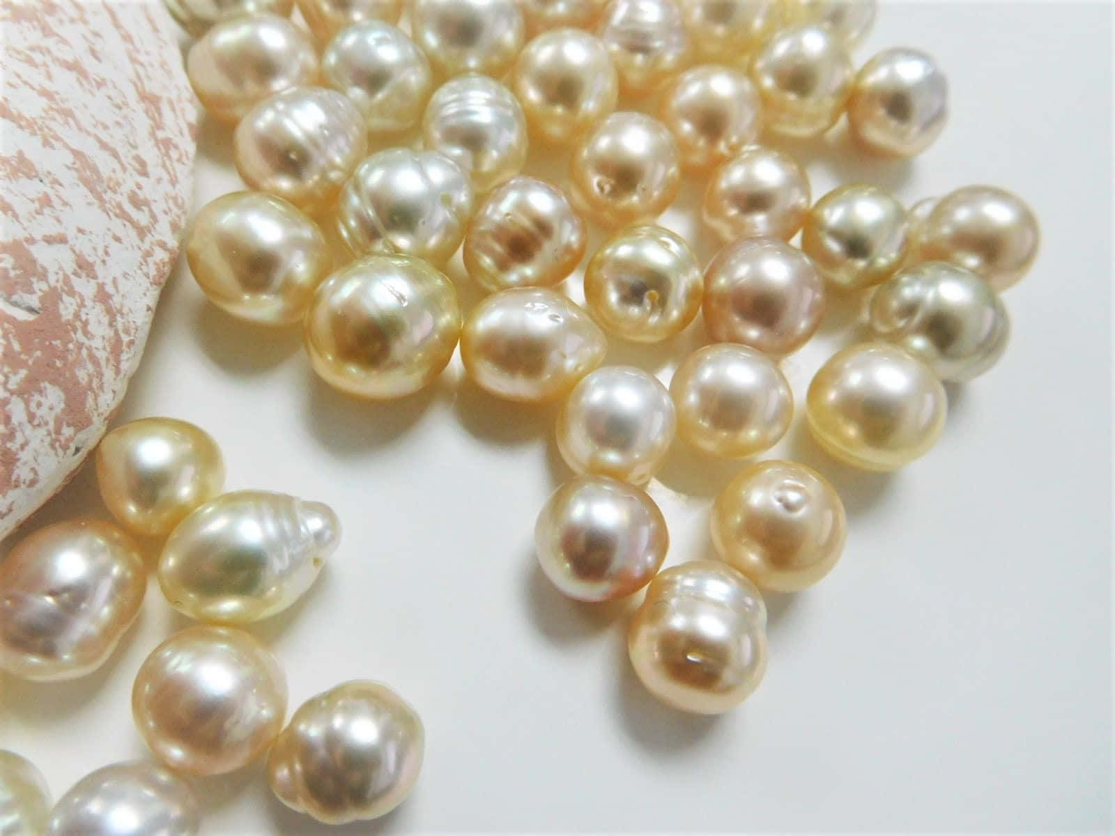 A Pile Of Pearls On A White Surface