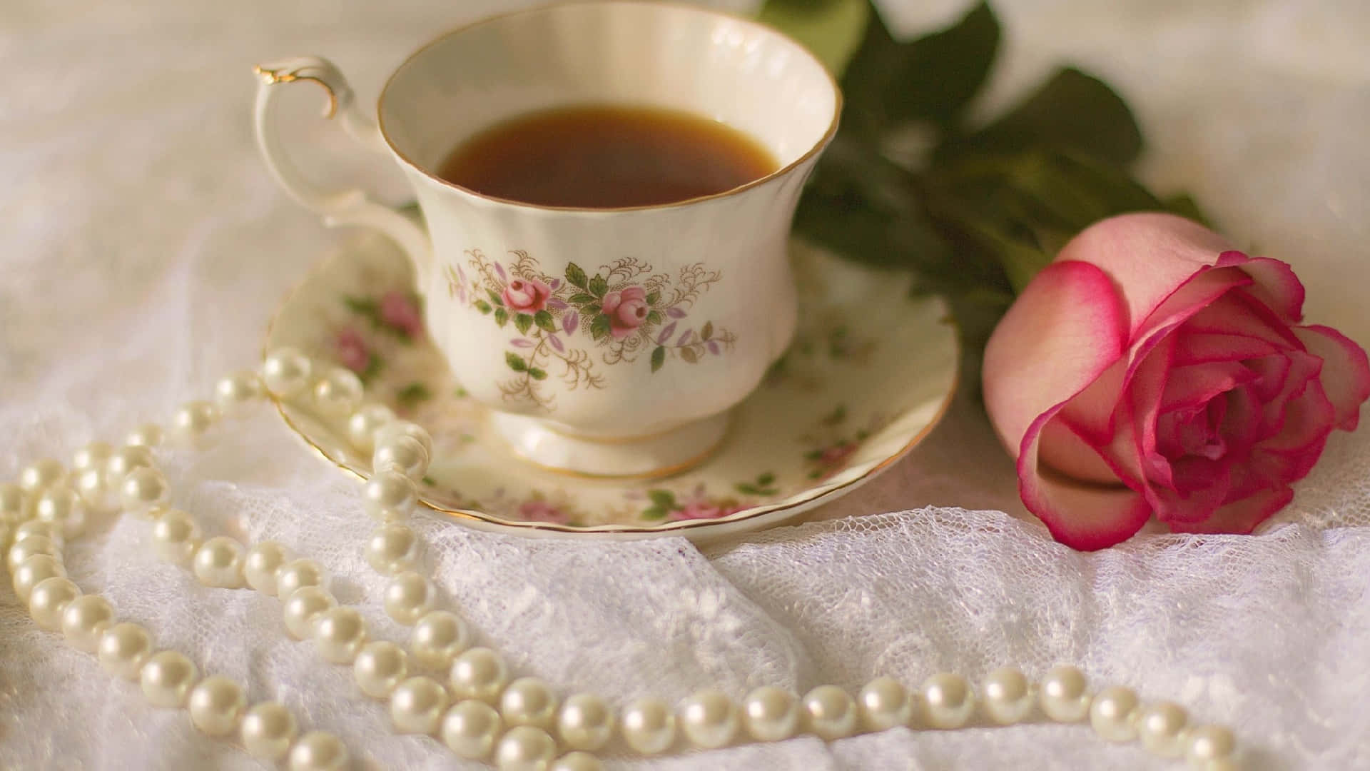 A Tea Cup With A Rose And Pearls