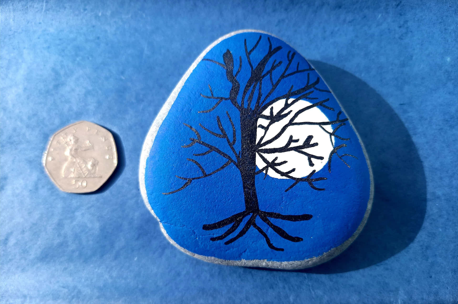 A Blue Stone With A Tree Painted On It