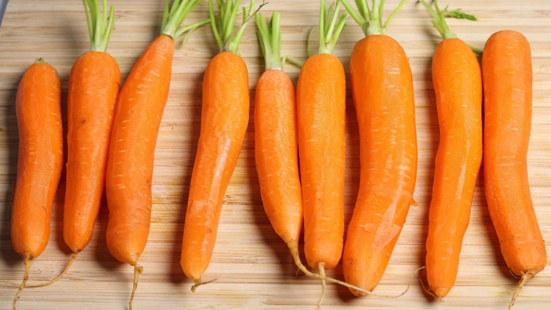 Zanahoriaspeladas De Raíz De Naranja En Diferentes Tamaños. Fondo de pantalla