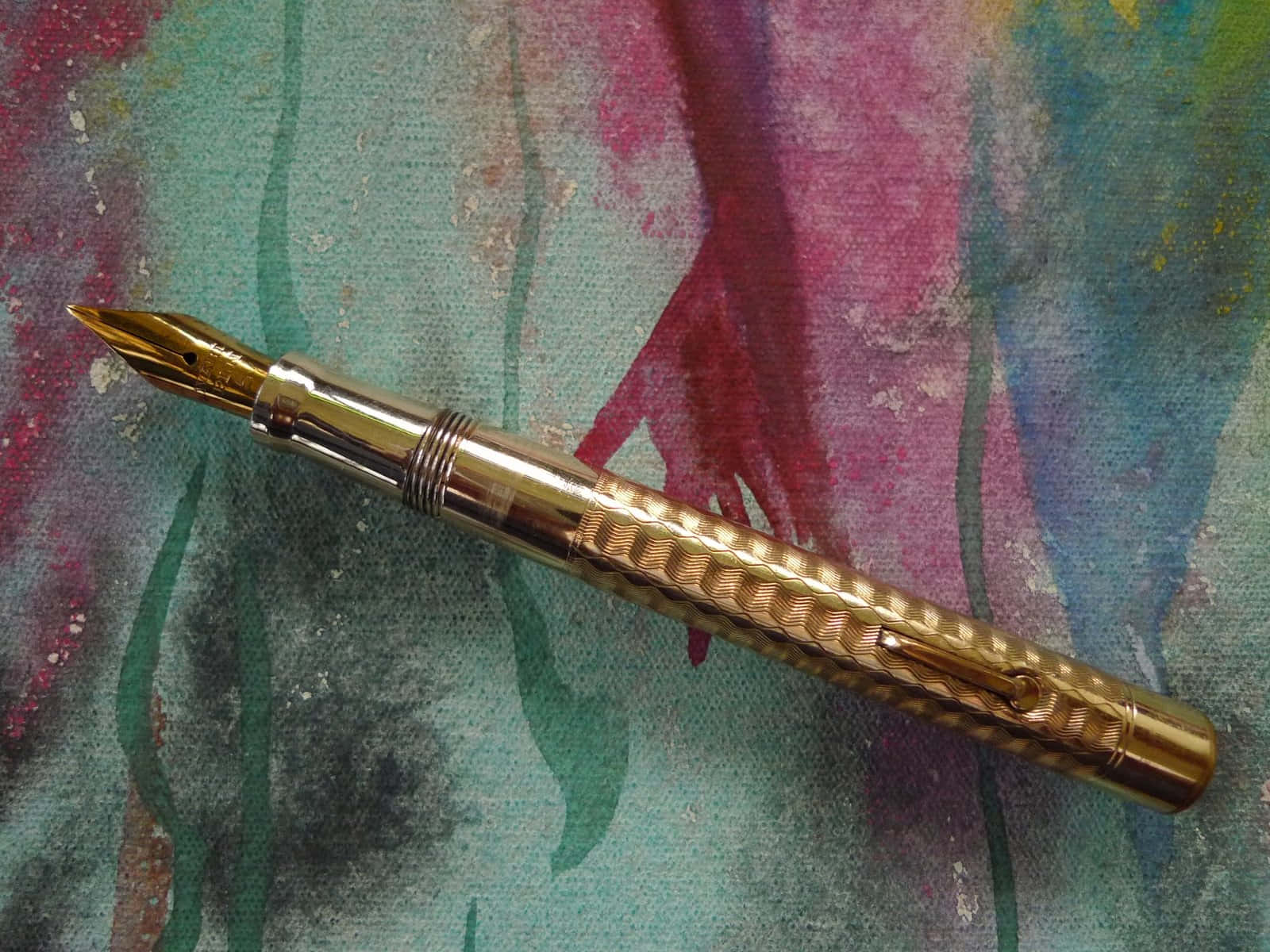 A Gold Pen On A Colorful Background