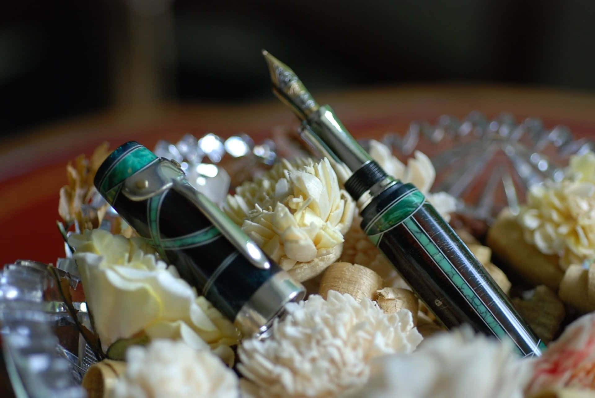 A Fountain Pen With Flowers In A Glass Bowl