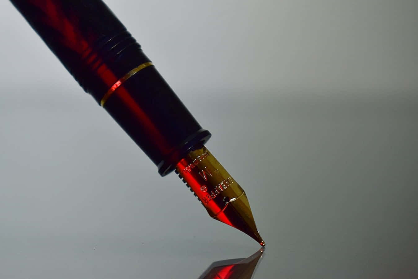 A Fountain Pen With A Red Light Shining On It