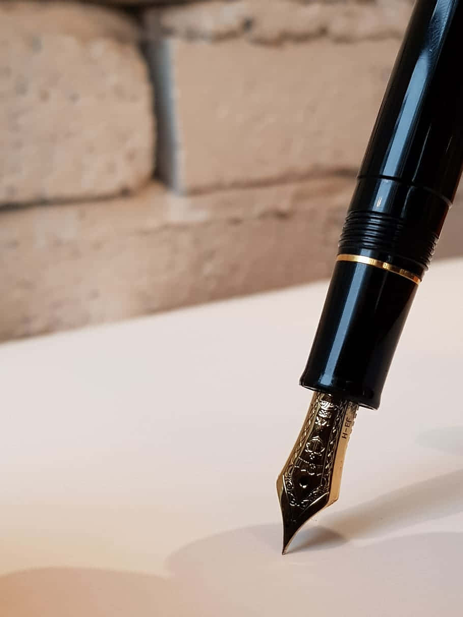 A Fountain Pen With A Black Nib On Top Of A White Paper