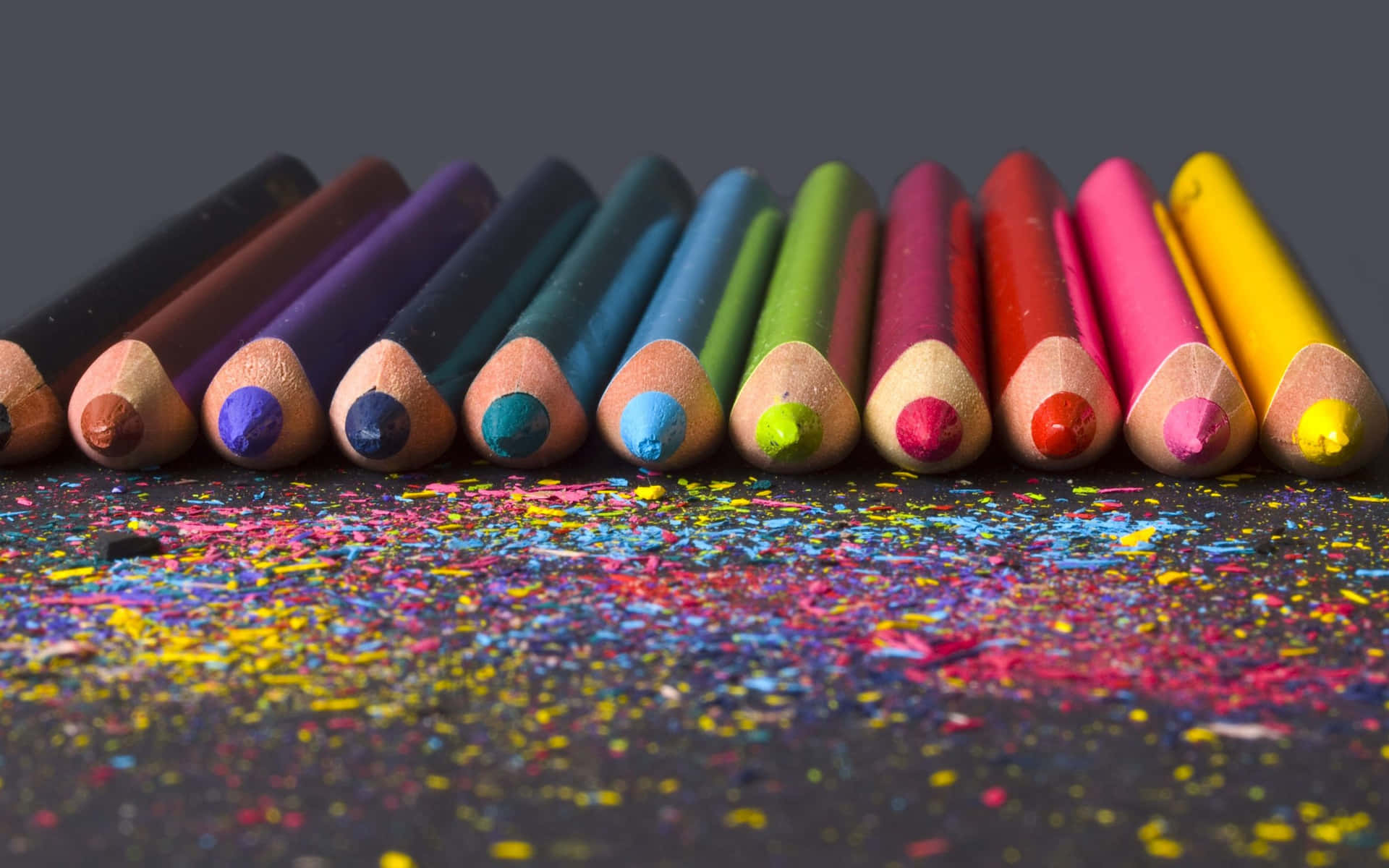 A Group Of Colored Pencils On A Black Background