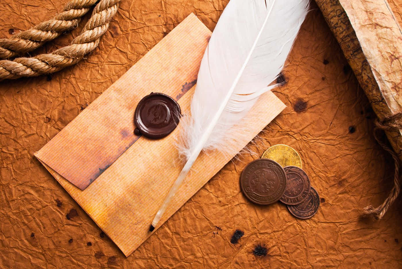 A Feather, Coins And Wax Seal On A Brown Background