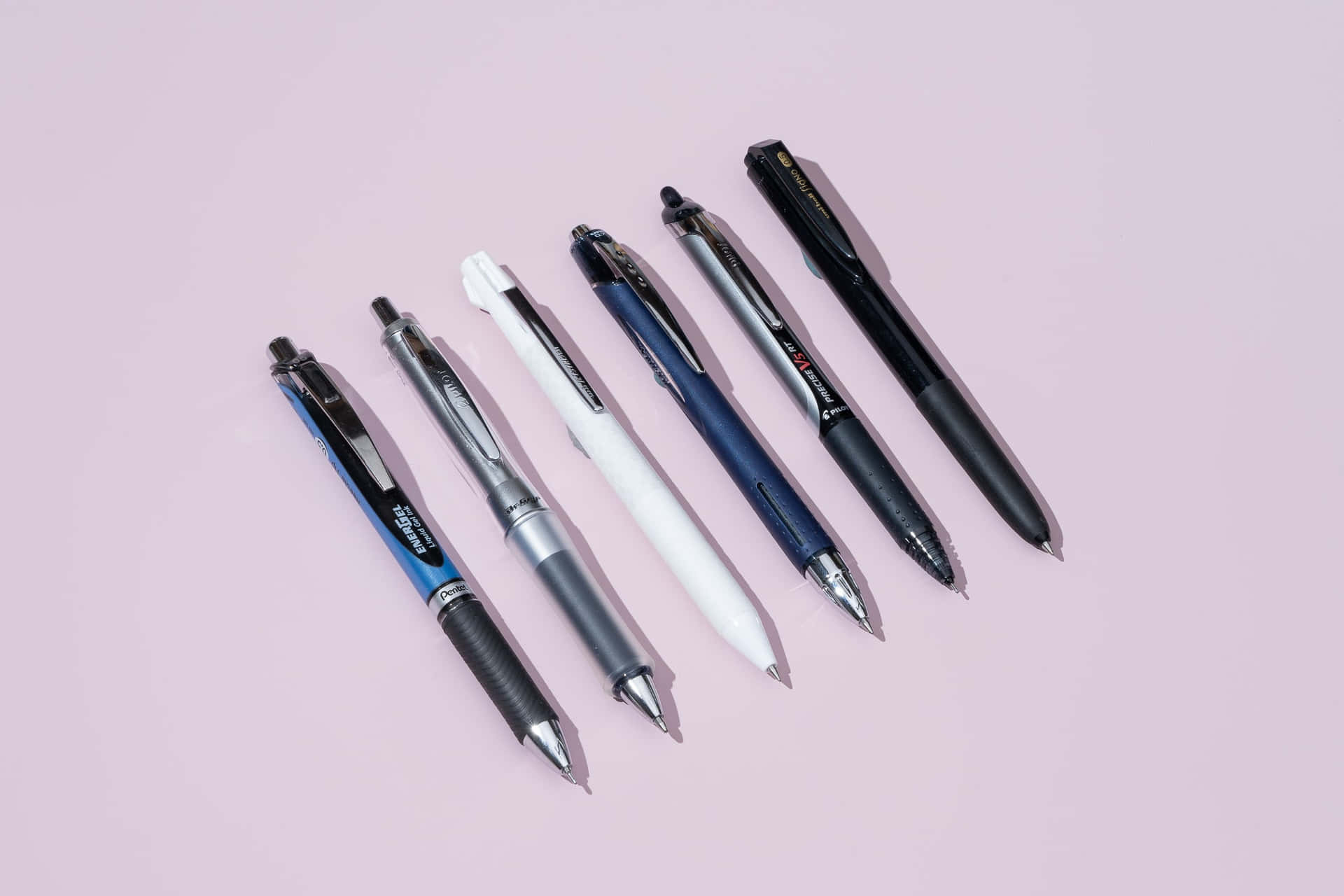 An array of colored pens against a white background.