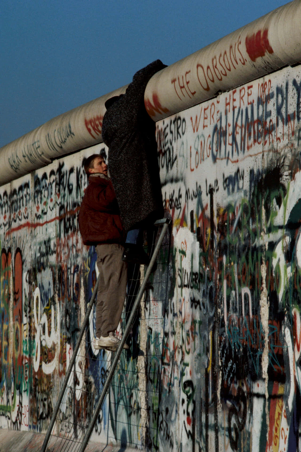 People Climbing On The Berlin Wall Wallpaper