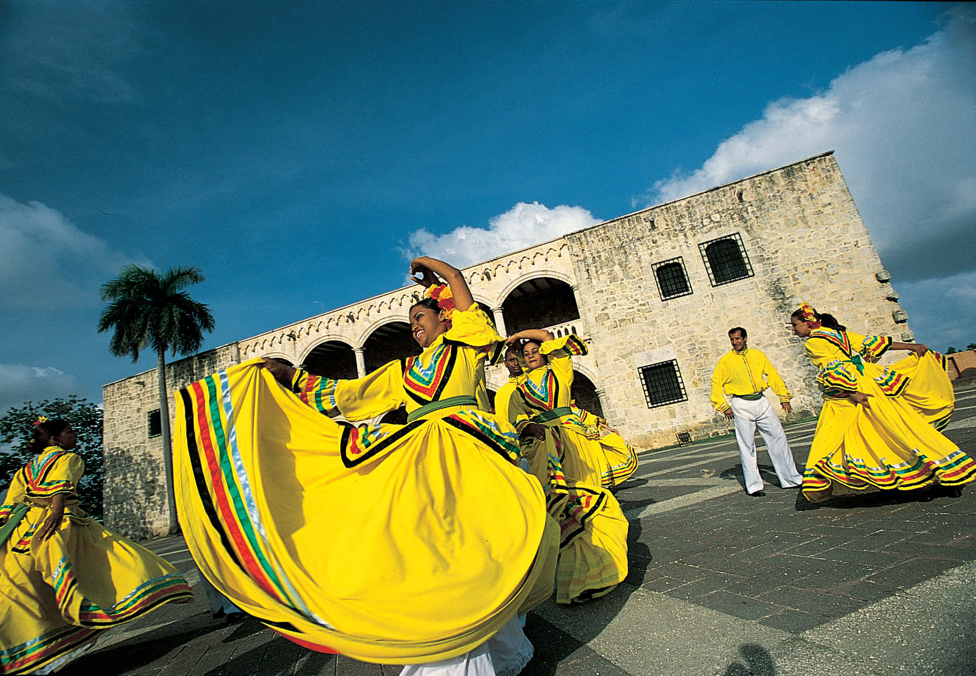 Personasen Amarillo Bailando Afuera Del Alcázar De Colón. Fondo de pantalla