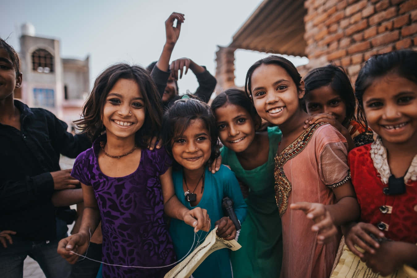 Einegruppe Von Mädchen Lächelt Vor Einem Gebäude.