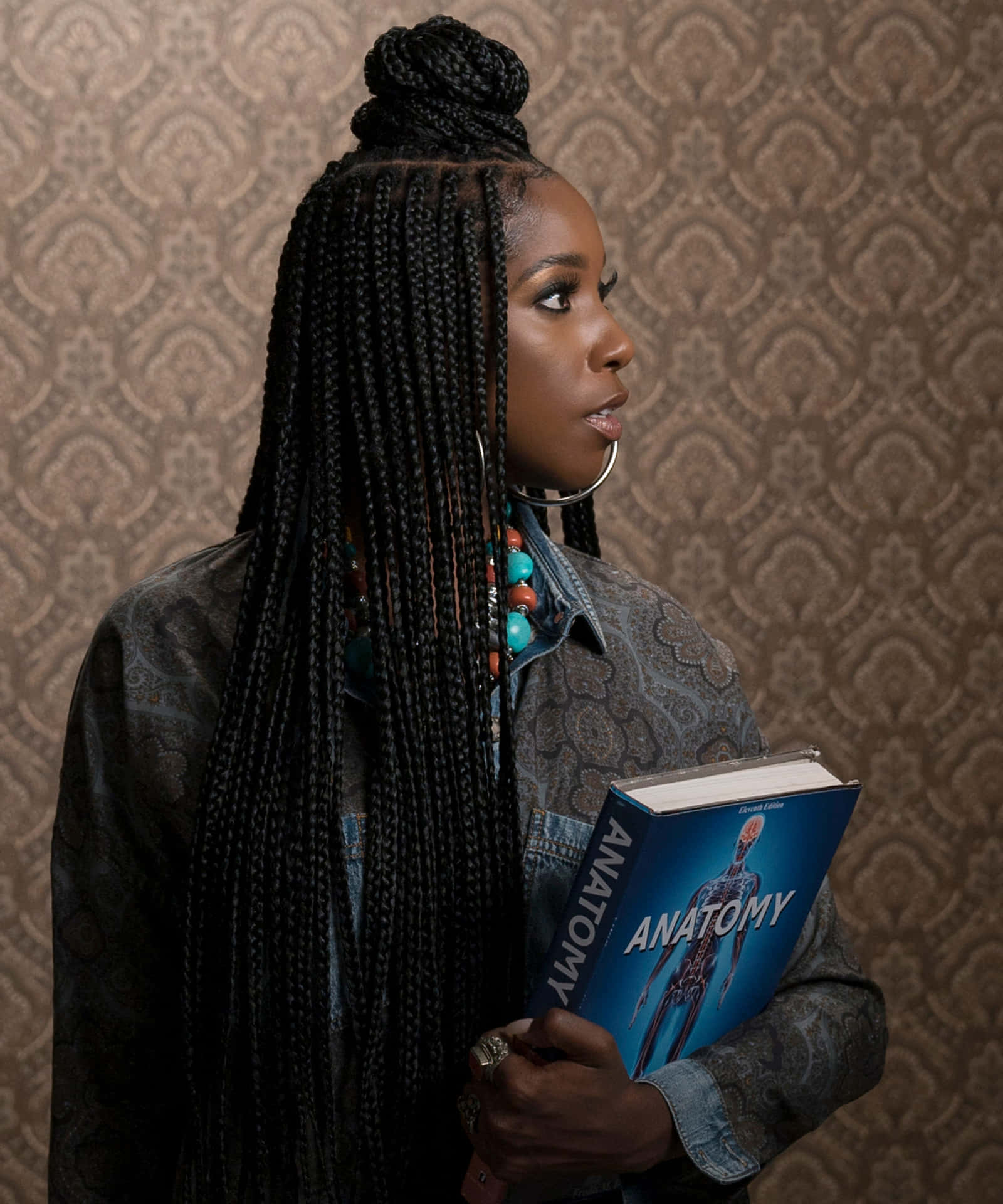 A Woman With Braids Holding A Book